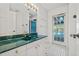 Bathroom featuring a green marbled countertop, white cabinets and pool view at 6103 6Th Nw Ave, Bradenton, FL 34209