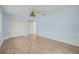 Spacious blue bedroom offers wood-look flooring, ceiling fan, closet, and natural light at 6103 6Th Nw Ave, Bradenton, FL 34209