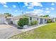 Side view of a single-story home featuring a well-maintained lawn, lush shrubbery, and an attached garage at 6103 6Th Nw Ave, Bradenton, FL 34209