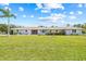 Charming single-story home with a well-manicured front lawn and inviting curb appeal, set against a blue sky at 6103 6Th Nw Ave, Bradenton, FL 34209