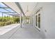 Wide covered patio featuring ceiling fans, with a screened view of the yard and lake beyond at 6103 6Th Nw Ave, Bradenton, FL 34209