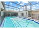Large enclosed pool with clear water and safety fence under a screened enclosure at 6103 6Th Nw Ave, Bradenton, FL 34209