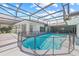 View of the enclosed pool with spa and safety fence, exterior view under a screened enclosure at 6103 6Th Nw Ave, Bradenton, FL 34209