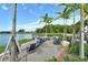 Outdoor sitting area with lake views with comfortable seating and lush landscaping under palm trees at 6204 Isla Del Ray Ave, Sarasota, FL 34240