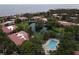 Aerial view of community featuring a pool, lake, landscaping, and condo buildings with red roofs at 6472 Seagull Dr # 301, Bradenton, FL 34210