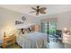 Bedroom features a comfortable bed, ceiling fan, and a sliding glass door to a private outdoor area at 6472 Seagull Dr # 301, Bradenton, FL 34210