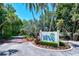 Community entrance sign 'Wild Oak Bay' surrounded by lush trees, greenery and a brick road at 6472 Seagull Dr # 301, Bradenton, FL 34210