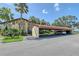 Exterior view of condo building with a car port and view of the property's mature landscaping at 6472 Seagull Dr # 301, Bradenton, FL 34210