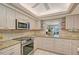 Kitchen with granite counters, stainless appliances, tile backsplash and bar passthrough to living room at 6472 Seagull Dr # 301, Bradenton, FL 34210