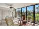 Enclosed lanai with seating area, ceiling fan, and scenic views of the lake and landscaping at 6472 Seagull Dr # 301, Bradenton, FL 34210