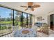 Enclosed lanai with a dining table, ceiling fan, and beautiful views of the lush greenery and pool at 6472 Seagull Dr # 301, Bradenton, FL 34210