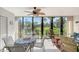 Enclosed lanai with a dining set, ceiling fan, and picturesque views of the pond and landscaping at 6472 Seagull Dr # 301, Bradenton, FL 34210