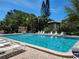 Community pool with ample lounge chairs, surrounded by lush landscaping creating a relaxing oasis at 6472 Seagull Dr # 301, Bradenton, FL 34210