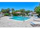 Community pool with ample seating, surrounded by lush tropical landscaping, and buildings with red tile roofs at 6472 Seagull Dr # 301, Bradenton, FL 34210
