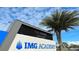 IMG Academy signage, honoring Nick Bollettieri, set against a backdrop of palm trees and a blue, cloudy sky at 6472 Seagull Dr # 301, Bradenton, FL 34210