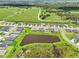 An aerial view showcases a residential neighborhood and nearby pond with homes lining the street at 6528 166Th E Pl, Parrish, FL 34219