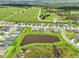 An aerial view showcases a residential neighborhood and nearby pond with homes lining the street at 6528 166Th E Pl, Parrish, FL 34219