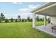 Expansive backyard with lush green lawn, covered patio, and peaceful surroundings at 6528 166Th E Pl, Parrish, FL 34219