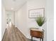 Bright hallway with luxury vinyl plank flooring and a decorative table with ornate plant at 6528 166Th E Pl, Parrish, FL 34219