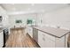 Bright, open kitchen boasts stainless appliances, white cabinets, large island, and adjacent dining area at 6528 166Th E Pl, Parrish, FL 34219