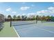 View of the tennis court featuring a net, fencing and benches for players at 6528 166Th E Pl, Parrish, FL 34219