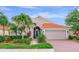 Charming single-story home featuring a red tile roof, brick driveway, and lush tropical landscaping at 6845 74Th Street E Cir, Bradenton, FL 34203