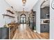 Inviting foyer featuring wood-look tile floors, storage, and bar area with views into the kitchen at 6845 74Th Street E Cir, Bradenton, FL 34203