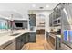 Open kitchen with stainless steel appliances, gray cabinets, and wood flooring at 6845 74Th Street E Cir, Bradenton, FL 34203