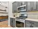 Close up on a modern kitchen with grey cabinets, stainless steel appliances and white quartz countertops at 6845 74Th Street E Cir, Bradenton, FL 34203