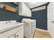 A clean laundry room featuring a washer and dryer, white cabinets, a sink, and wood-look tile flooring at 6845 74Th Street E Cir, Bradenton, FL 34203