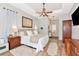 Relaxing primary bedroom featuring wood-look tile floors, tray ceilings, a ceiling fan, and an attached full bathroom at 6845 74Th Street E Cir, Bradenton, FL 34203