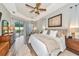 Serene primary bedroom with patio access, neutral tones, and a ceiling fan at 6845 74Th Street E Cir, Bradenton, FL 34203