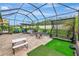 A large screened-in patio with a fire pit, seating, and a baseball training area, ideal for outdoor entertainment at 6845 74Th Street E Cir, Bradenton, FL 34203