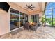 Covered patio with a ceiling fan, tile flooring, and dining table with seating for enjoying outdoor meals at 6845 74Th Street E Cir, Bradenton, FL 34203