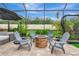 A beautiful screened-in patio with a fire pit, comfortable seating, and lush landscaping creating a relaxing outdoor oasis at 6845 74Th Street E Cir, Bradenton, FL 34203