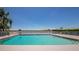 Community pool with lounge chairs overlooking a scenic lake and blue skies at 6845 74Th Street E Cir, Bradenton, FL 34203