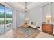 Bright seating area with wood-look floors, a white couch, and sliding glass doors to the exterior patio at 6845 74Th Street E Cir, Bradenton, FL 34203