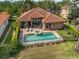 Aerial view of home and pool, with a jacuzzi spa and lounge chairs at 7521 Aralia Way, Seminole, FL 33777