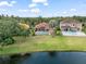 Aerial view of homes with lake views and a well-manicured lawn at 7521 Aralia Way, Seminole, FL 33777