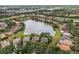 An aerial view displays lakefront homes surrounded by mature trees in a serene community at 7521 Aralia Way, Seminole, FL 33777