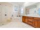 Relaxing bathroom featuring a garden tub, step-in shower, double vanity, and neutral tile at 7521 Aralia Way, Seminole, FL 33777