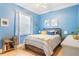 Cozy bedroom with blue walls, a ceiling fan, a window, and a comfortable bed with colorful accents at 7521 Aralia Way, Seminole, FL 33777
