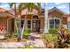 Inviting front entry with brick pathway leading to a decorative glass front door at 7521 Aralia Way, Seminole, FL 33777