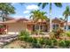 Beautifully landscaped single-Gathering home featuring a clay tile roof and attached two-car garage at 7521 Aralia Way, Seminole, FL 33777