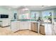 Kitchen with stainless steel dishwasher and sink looking to the water outside the sliding glass doors at 7521 Aralia Way, Seminole, FL 33777