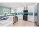 Well-equipped kitchen with stainless steel appliances, white cabinets, and tile backsplash at 7521 Aralia Way, Seminole, FL 33777