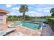 Backyard pool and spa offer a relaxing view of the community lake at 7521 Aralia Way, Seminole, FL 33777