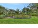 Backyard featuring a garden with vegetable plantings and flower garden bordered by decorative fencing and lush greenery, creating a private oasis at 7604 Weeping Willow Cir, Sarasota, FL 34241
