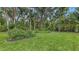 A lush, green backyard features well-manicured lawn and garden beds, providing a serene and private outdoor retreat at 7604 Weeping Willow Cir, Sarasota, FL 34241