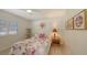 Bedroom with floral bedding, ceiling fan and bright natural light at 7604 Weeping Willow Cir, Sarasota, FL 34241